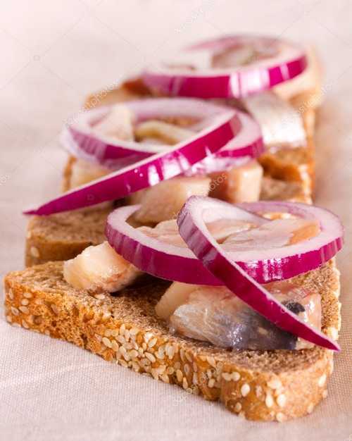 Сэндвич из ржаного хлеба с селедкой и репчатым луком